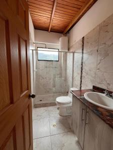 a bathroom with a toilet and a sink at Refugio de Guacamayas in Mérida