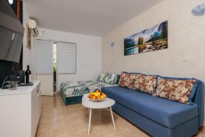 a living room with a blue couch and a table at Mir & More in Budva