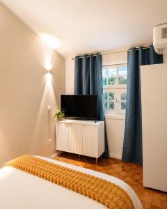 ein Schlafzimmer mit Bett und Flachbildfernseher in der Unterkunft Opus House in Guimarães