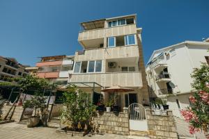 a tall building with an umbrella in front of it at Mir & More in Budva