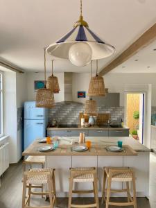 a kitchen with a large island with chairs and a table at LES POIS SONT ROZ in Perros-Guirec