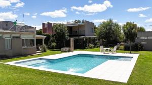 a swimming pool in the yard of a house at La Cañada Chascomús in Chascomús