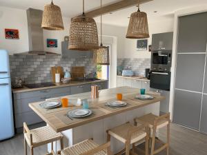 a kitchen with a large island with chairs and a table at LES POIS SONT ROZ in Perros-Guirec +26 photos
