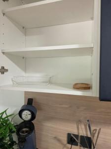 a clock sitting on top of a shelf in a kitchen at T2 proche gare & centre ville climatisé in Castres +17 photos