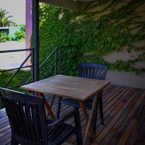 a wooden table and two chairs on a deck at La Cañada Chascomús in Chascomús