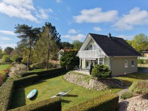 a house with a garden and a boat in the yard at Ferienhaus Seestern direkt am Plauer See in Plau am See