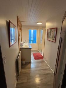 a hallway of a bathroom with a sink and a mirror at Le Gîte Chez Mémé in Lavelanet +7 photos