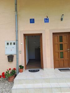an entrance to a building with a door and flowers at Apartmani Sorić in Prijeboj