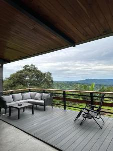 a porch with a couch and a chair on a deck at Finca Mirador De Gualaca in Gualaca