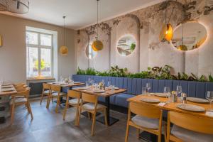 ein Restaurant mit Holztischen und -stühlen und Spiegeln in der Unterkunft BELROS Hotel in Trenčín