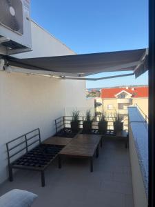 a patio with benches and tables on a balcony at Apartment 98A7 in Povljana +79 photos