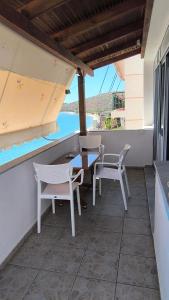 a patio with a table and chairs and a view of the ocean at Q Bay Apartments in Qeparo