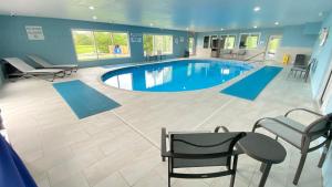 a large pool in a room with chairs and a table at Holiday Inn Express Bluffton by IHG in Bluffton