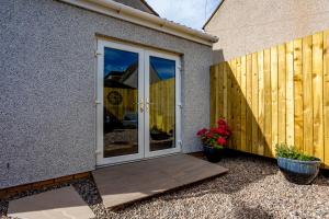 a sliding glass door on the side of a house at The Hide at St Andrews in Fife
