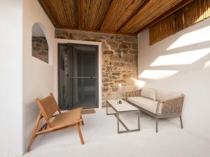 a living room with a couch and a chair at Mylopetra Suites Sarti in Sarti