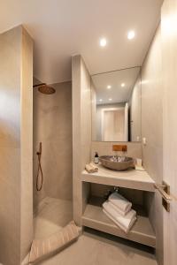 a bathroom with a sink and a mirror at Mylopetra Suites Sarti in Sarti