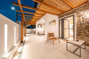 a room with a stone wall and wooden ceilings at Mylopetra Suites Sarti in Sarti