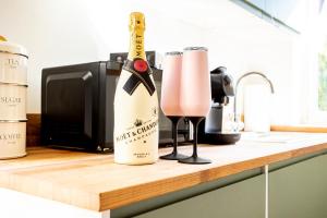 a bottle of champagne and two glasses on a counter at The Hide at St Andrews in Fife +6 photos