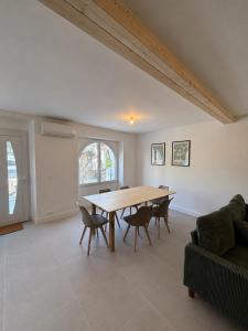 a dining room with a wooden table and chairs at Maison de vacance à DAX in Dax