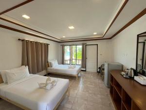 a hotel room with two beds and a desk at SWIMS! a Social Beach Resort in Haad Rin