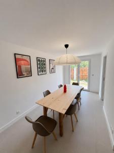 a dining room with a wooden table and chairs at Maison de vacance à DAX in Dax