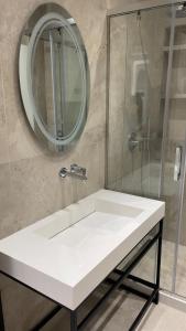 a bathroom with a white sink and a mirror at DreamStay Lezha Apartments - Ilyonis Residence in Lezhë +35 photos