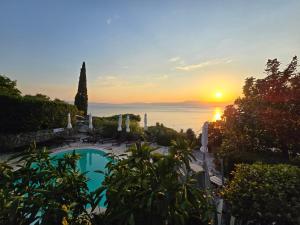 a swimming pool with the sunset in the background at Apartments Villa Dora in Kraljevica
