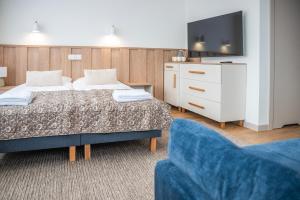a room with two beds and a tv and a couch at Pokoje ABC Centrum in Ustka