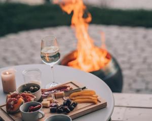 a table with a plate of food and a glass of wine at Anton & Cilli Hideaway Lodges in Obermaiselstein