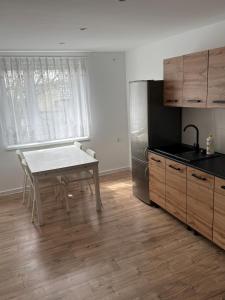 a kitchen with a white table and a refrigerator at Agroturystka Nowotny in Zawada Książęca +2 photos