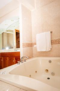 a white bath tub in a bathroom with a mirror at Hotel Fiesta Alteña in Tepatitlán de Morelos +41 photos