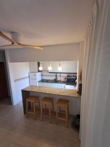 a kitchen with a counter and stools in a room at Ático Chipre naturist FKK Vera-playa in Vera