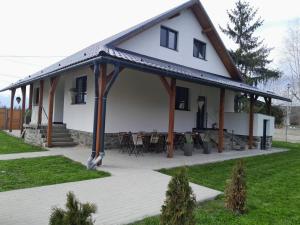 a large white house with a large patio at Bara Apartment and Studio in Gheorgheni
