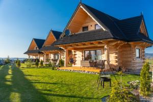 a log home with a black roof at Sękata Chata góralski domek z kominkiem in Szaflary