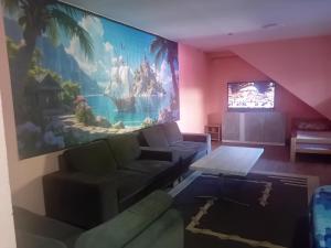 a living room with a couch and a large painting on the wall at Red Apartman in Trebinje