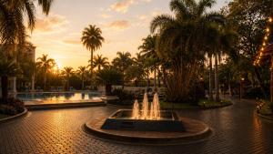 a fountain in the middle of a courtyard with palm trees at Turismo Hotel Casino in Corrientes