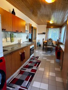 a kitchen with wooden cabinets and a tile floor at Chata na Špince in Červený Kostelec +42 photos