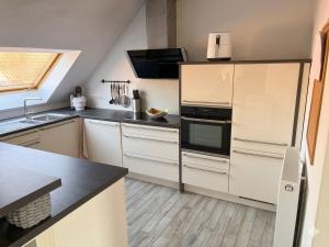 a kitchen with white cabinets and a black appliance at Modernes Landhaus Modern country house in Kalkar