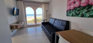 a living room with a couch and a view of the ocean at Apartamentos Regollera in Noja