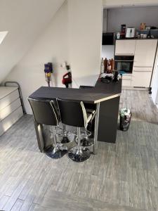 a kitchen with a black table and some chairs at Modernes Landhaus Modern country house in Kalkar