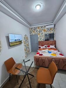 a bedroom with a bed and a table and chairs at 1e Studio Moderne au cœur de Cocody 7e tranche- Tout inclus in Cocody