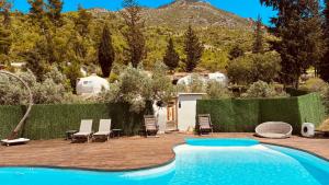 a swimming pool in a yard with chairs at Vita Nova Hotel in Olympos