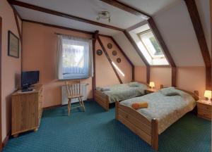 a bedroom with two beds and a television in it at Sobiesz - Pokoje Gościnne in Jagniątków