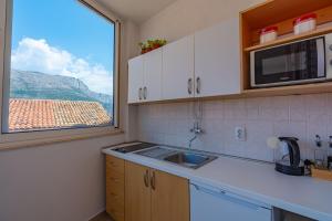 a kitchen with a sink and a window at Lumina Apartments in Korčula +20 photos