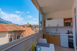 a kitchen with a view of a city from a balcony at Lumina Apartments in Korčula