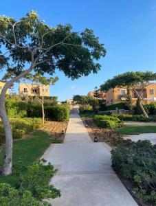 a walkway in a park with trees and houses at Mountain View luxe chalet Ras elhikma families only in Ras Elhekma
