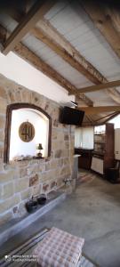 a room with a stone wall with a clock on the wall at Il Borghetto Country Charme in Cefalù