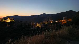 a view of a city at night with mountains in the background at Pyrgos Mitsakou in Vathia +3 photos