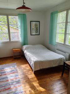 a bedroom with a bed in a room with windows at Hirsipirtti in Inari