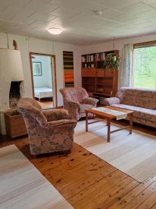 a living room with chairs and a couch and a table at Hirsipirtti in Inari
